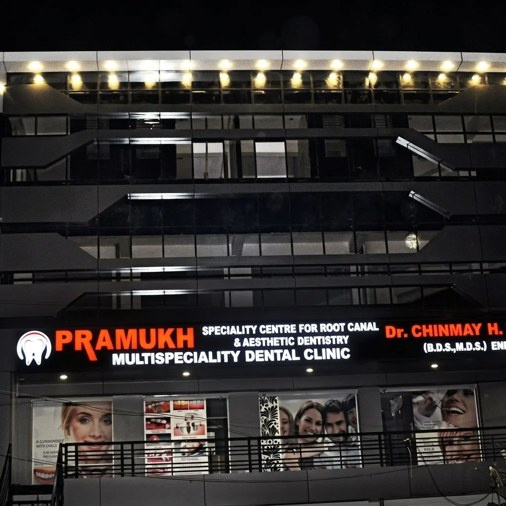 Pramukh Dental clinic building illuminated at night, Radhanpur Circle, Mehsana